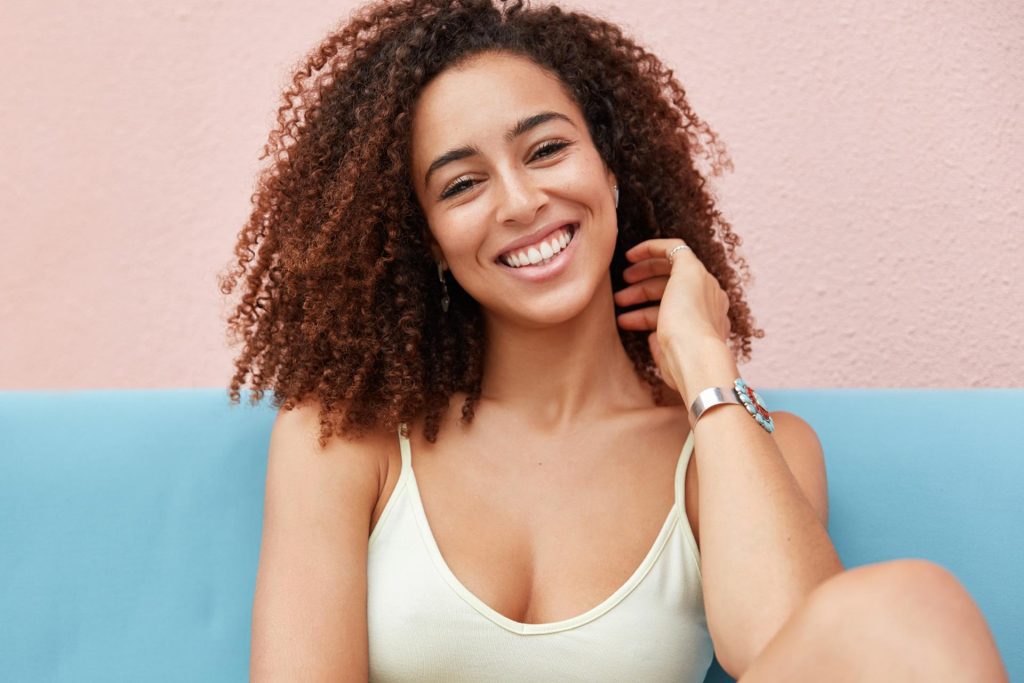 Happy woman against pink backdrop