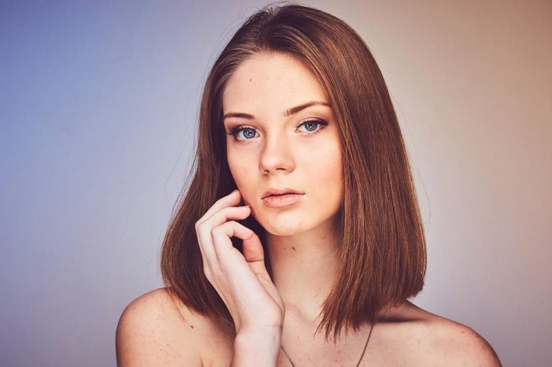 Woman with straight brown hair posing