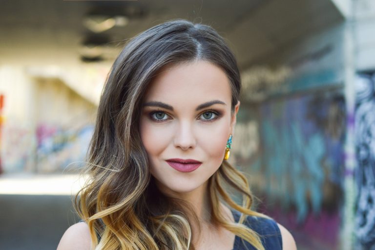 Woman posing in graffiti-covered alley